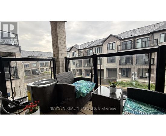 A balcony with a table and chairs overlooking a row of houses.