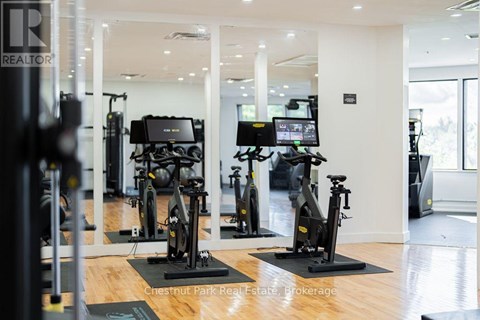 A gym with a row of stationary bikes.