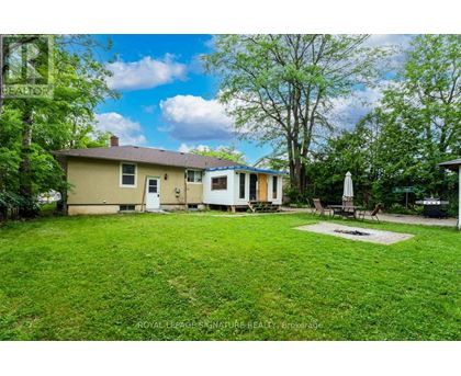 A house with a lawn and trees in the background.