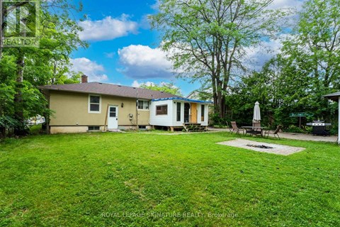 A house with a lawn and trees in the background.
