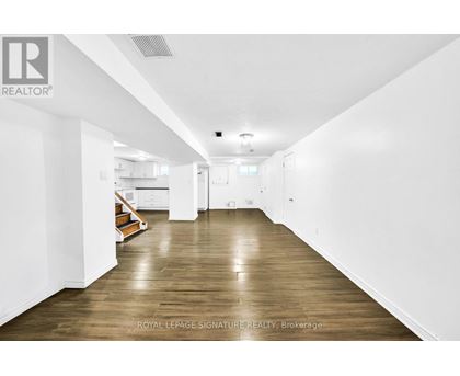 A long hallway with wooden floors and white walls.