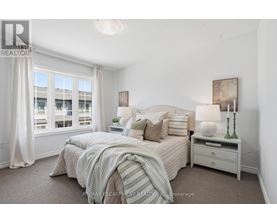 A bedroom with a large bed and a window with curtains.