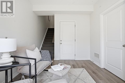 A living room with a couch, a lamp, a coffee table and a staircase.