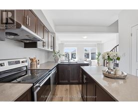 A modern kitchen with dark wood cabinets and stainless steel appliances.
