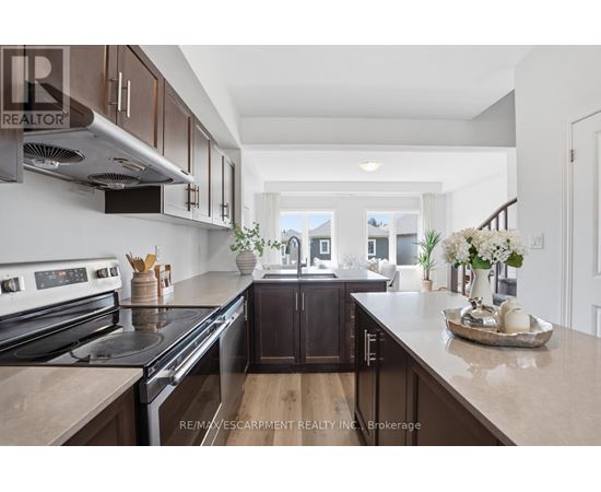A modern kitchen with dark wood cabinets and stainless steel appliances.