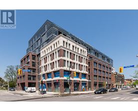 A street view of a multi-story building with a clear blue sky above.