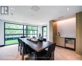 A modern dining room with a wooden table and chairs.