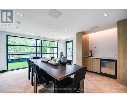 A modern dining room with a wooden table and chairs.