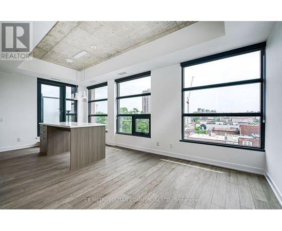 A spacious office room with a desk and large windows overlooking a cityscape.