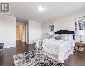 A bedroom with a large bed and a chair.