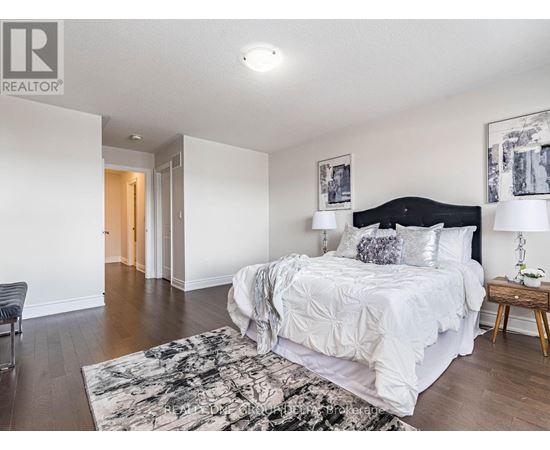 A bedroom with a large bed and a chair.
