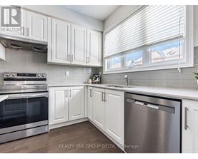 A kitchen with white cabinets and a stainless steel dishwasher.