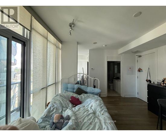 A bedroom with a bed, a desk, and a chair.