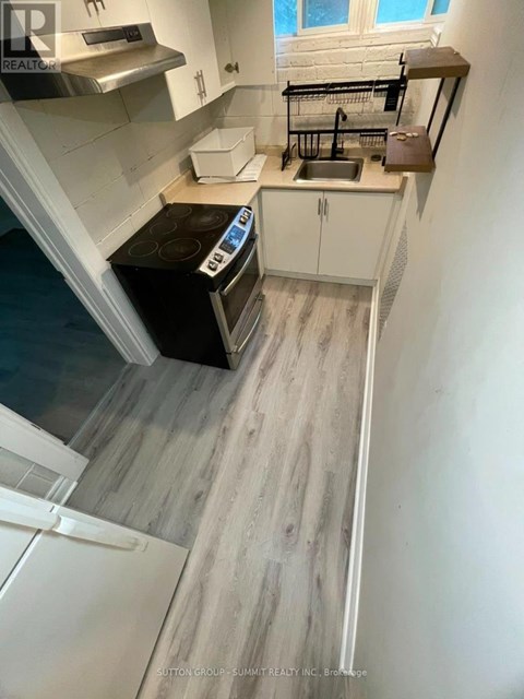 A kitchen with a black stove top oven and white cabinets.
