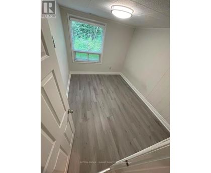 A room with a window and wooden flooring.