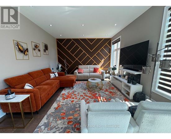 A living room with a brown sofa, a white armchair, and a patterned rug.