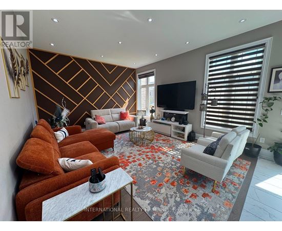 A living room with a grey rug and a brown sofa.