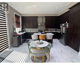 A kitchen with a table and chairs in the middle.