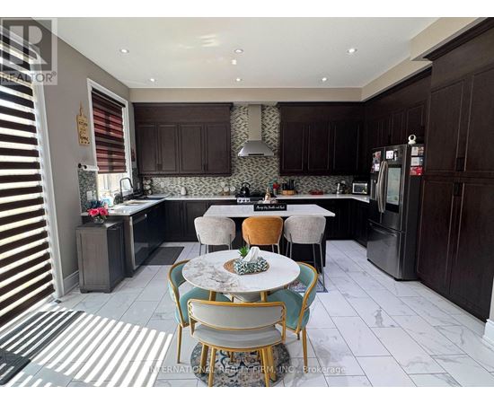 A kitchen with a table and chairs in the middle.