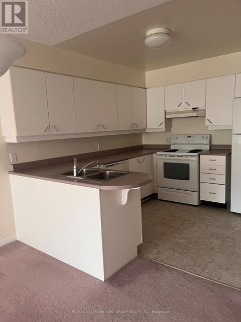 A kitchen with white cabinets and a white fridge.