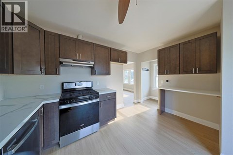A kitchen with a stove top oven and a refrigerator.