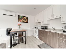 A kitchen with a table and chairs and a painting on the wall.