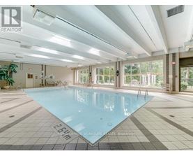 A large indoor swimming pool with a tiled floor and walls.