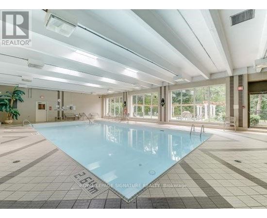 A large indoor swimming pool with a tiled floor and walls.