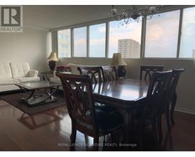 A dining room with a table and chairs.