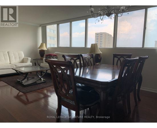 A dining room with a table and chairs.