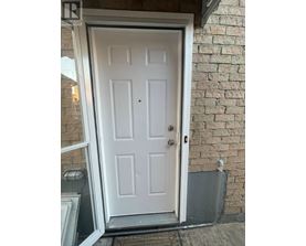A white door with a black handle is set in a brick wall.