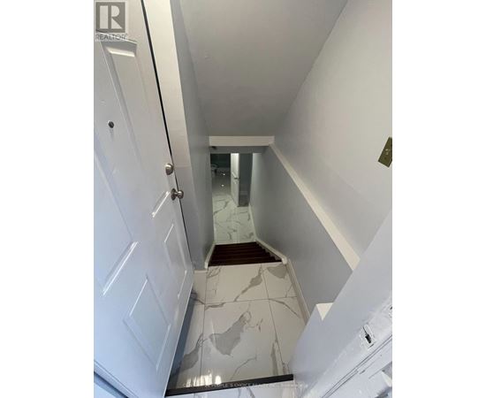 A hallway with a white door and a marble floor.
