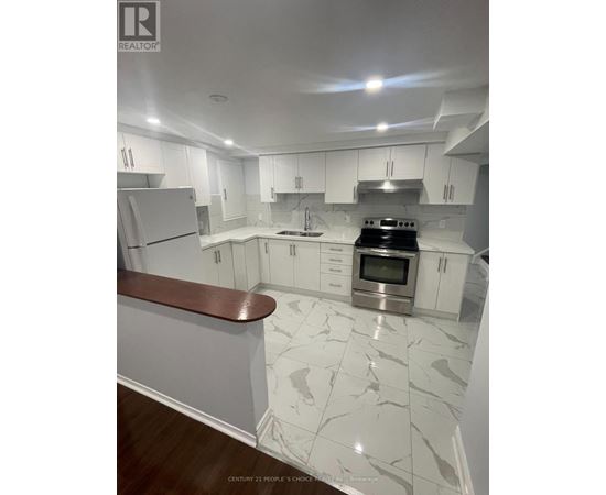 A modern kitchen with white cabinets and a marble floor.