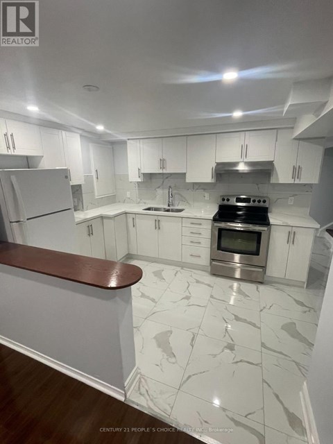 A modern kitchen with white cabinets and a marble floor.