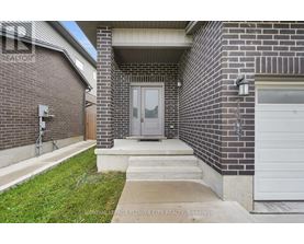 A brick house with a grey door and a white garage door.