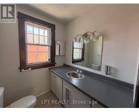 A bathroom with a sink, mirror, and toilet.