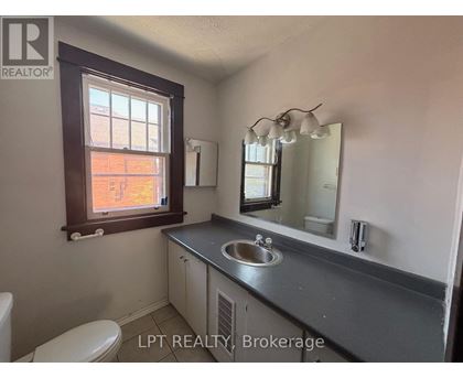 A bathroom with a sink, mirror, and toilet.