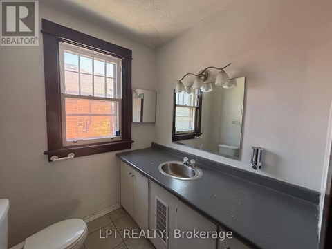 A bathroom with a sink, mirror, and toilet.