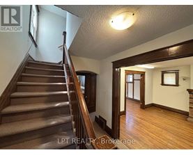 A staircase with a wooden banister and steps leading up to a doorway.