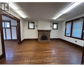A room with a fireplace and wood flooring.