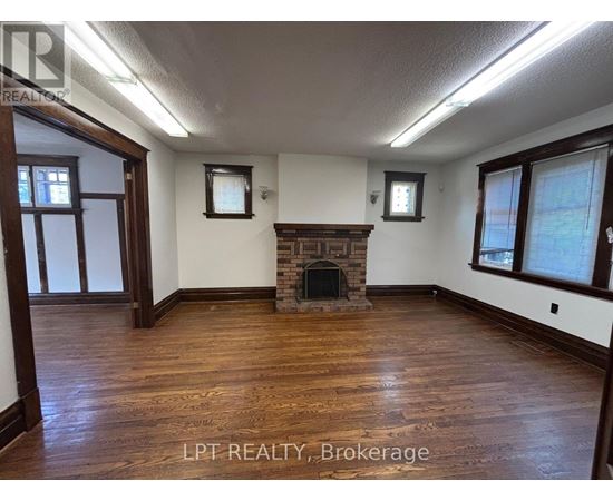 A room with a fireplace and wood flooring.