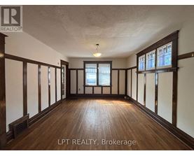 A spacious room with wooden floors and white walls.