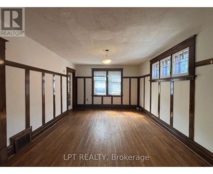 A spacious room with wooden floors and white walls.