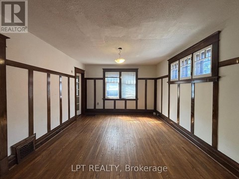 A spacious room with wooden floors and white walls.
