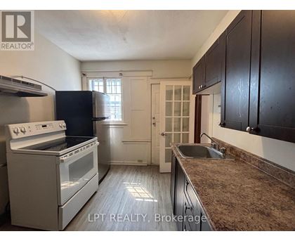 A kitchen with a white stove and black cabinets.