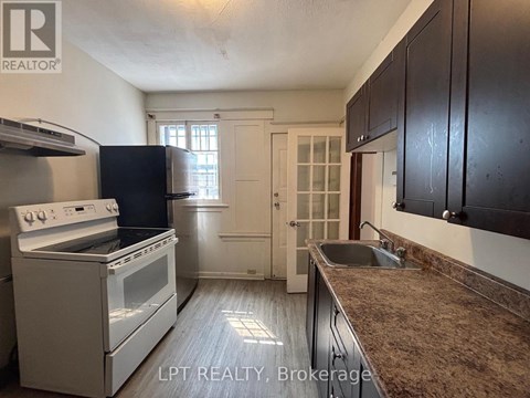 A kitchen with a white stove and black cabinets.