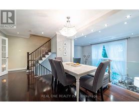 A dining room with a table set for two and a chandelier hanging from the ceiling.