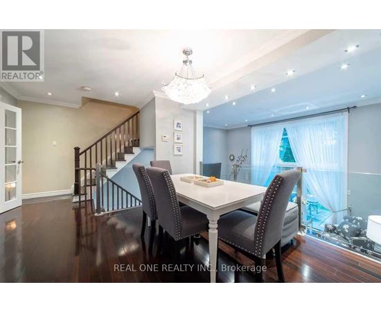 A dining room with a table set for two and a chandelier hanging from the ceiling.