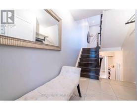 A white chair is placed in a room with a mirror on the wall.