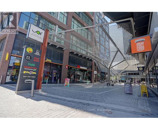A street view of a shopping area with various store signs.